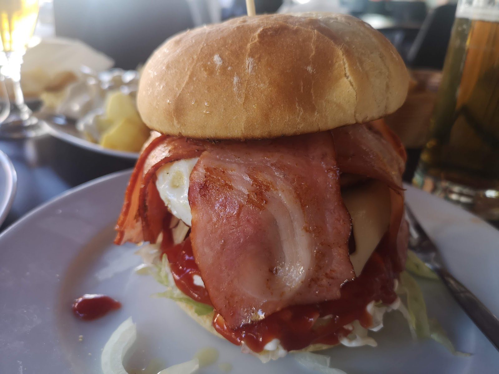 Hamburguesa completa con huevo frito, bacon crujiente y pan brioche.